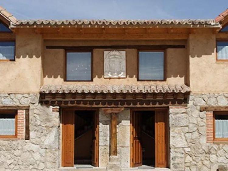 a stone building with windows and a sign on it at Casa El Pajar De Tasio in San Miguel del Pino