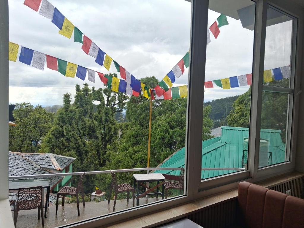 a balcony with a view of a house with flags at Nanda niwas 2 in McLeod Ganj