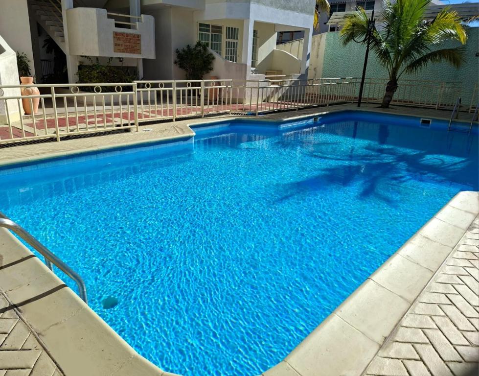 a large blue swimming pool in a building at Appartment Camellia in Flic-en-Flac