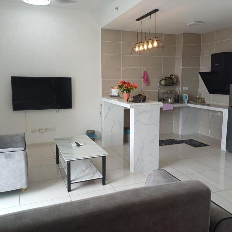a living room with a table and a tv at Sunway Onsen Apartment Tambun by ELK Homestay in Tambun