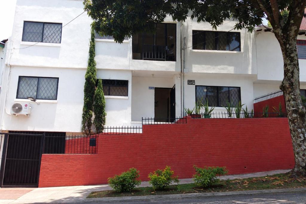 a house with a red fence in front of it at Casa Esperanza in Cali