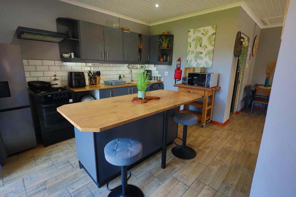 a kitchen with a island with a wooden counter top at PINE COTTAGE Self catering fully equipped 2 bedroom, Queen bed 3 singles 65sqm cosy private cottage in Durban