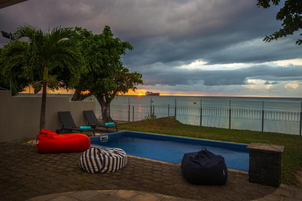 a swimming pool with a view of the ocean at Bahari Villa Beachfront in Port Louis