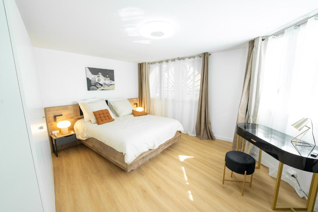 a bedroom with a bed and a desk in it at Appartement rénové avec parking quartier historique in Bordeaux