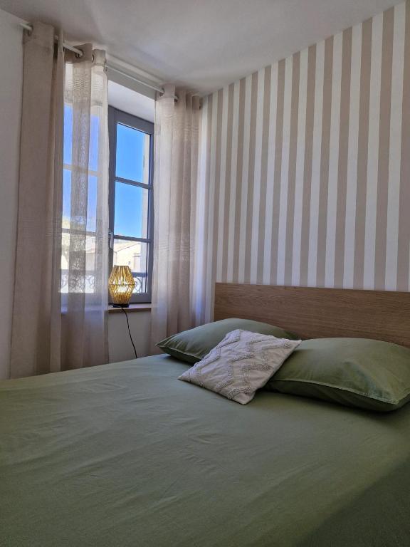 a bedroom with a large bed with a window at La place in Pont-de-Vaux