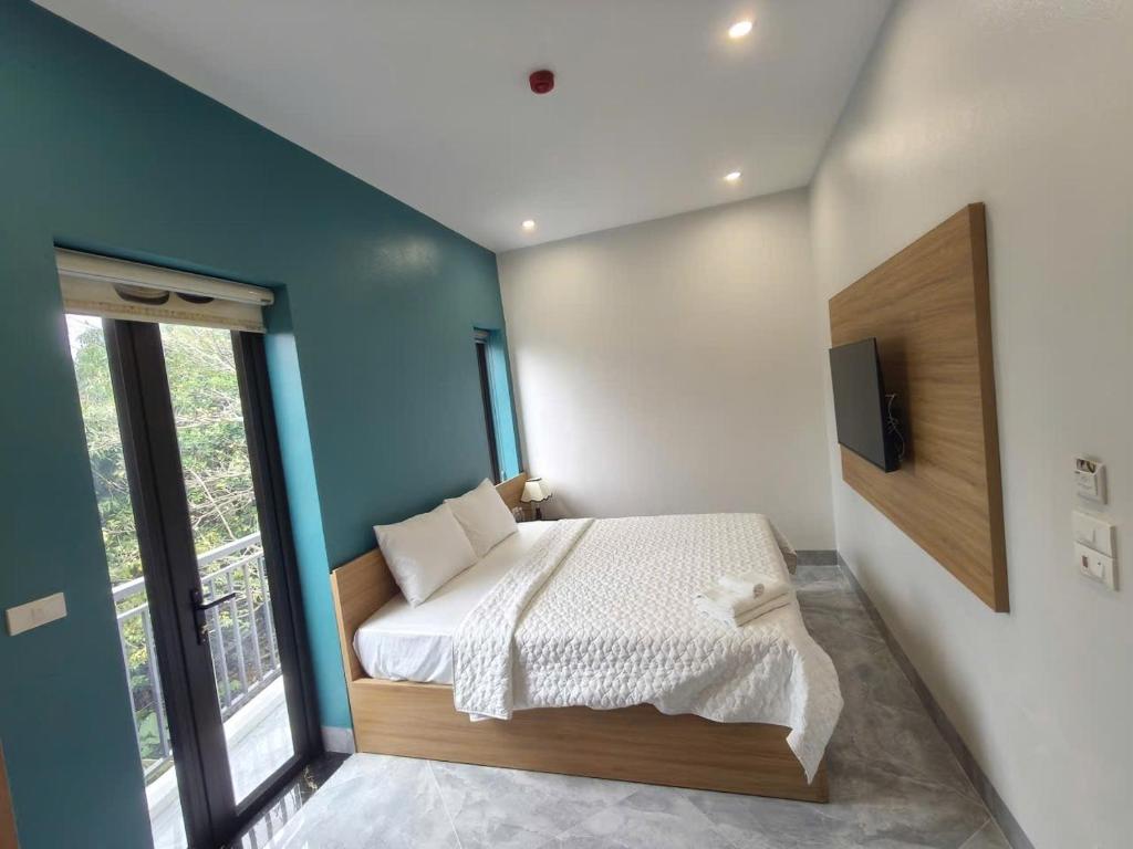 a bedroom with a bed and a tv on a wall at Tam Coc Sunflower Hotel in Ninh Binh