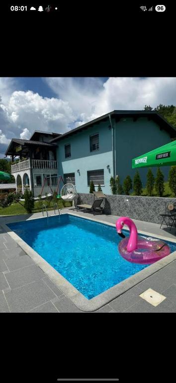 a swimming pool with a pink flamingo float in front of a building at PRENOCiSTE SARA in Bihać