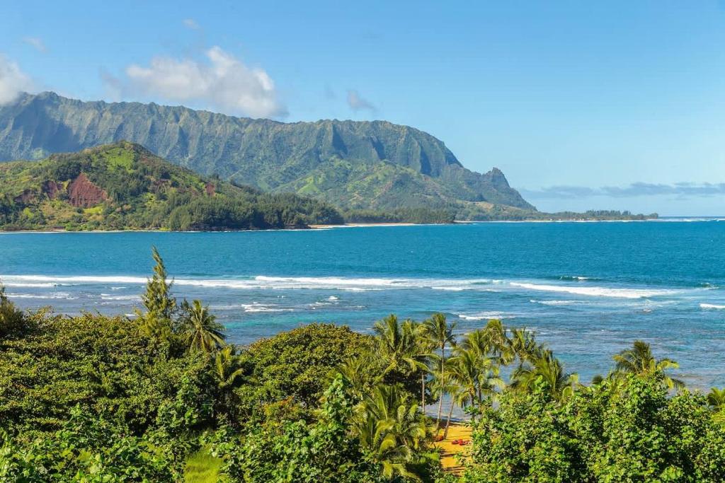 a view of the ocean with mountains in the background at NEW Sunset Hideaway with Beach Access Pools & AC in Princeville
