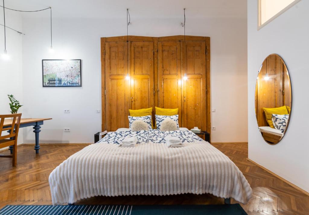 a bedroom with a bed with a wooden headboard at Mignon Szeged Apartman in Szeged