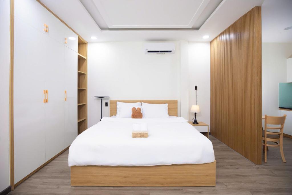 a bedroom with a large white bed and a desk at Board & Beyond House in Danang