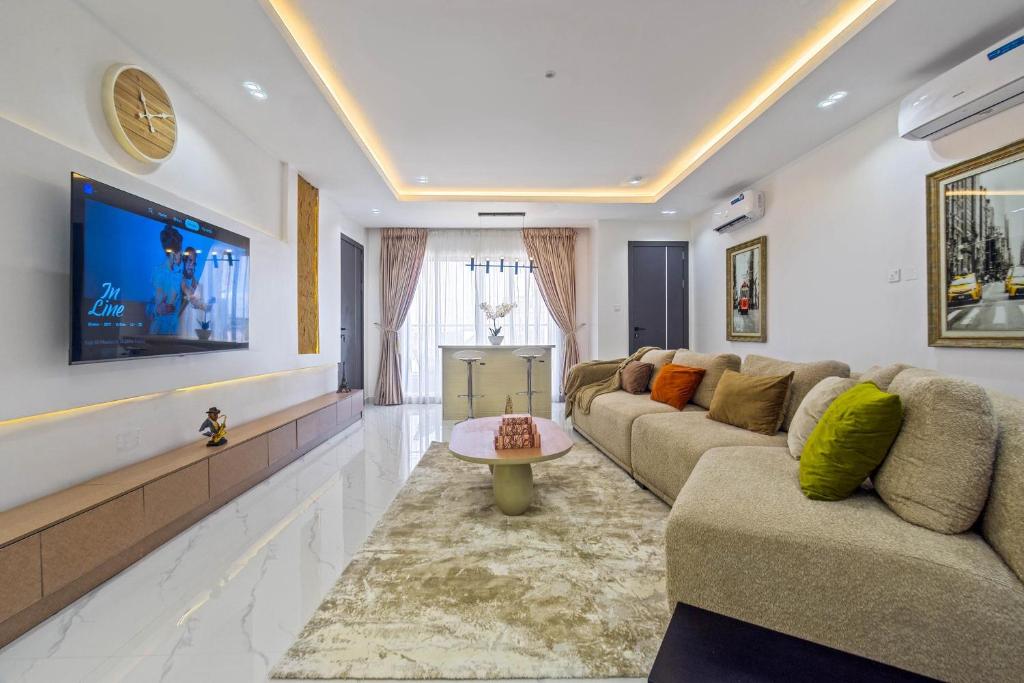 a living room with couches and a flat screen tv at Mex 1 bedrooms Lekki phase1 in Lagos