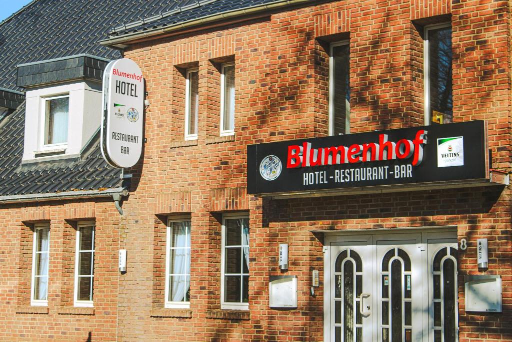 a brick building with a sign on the side of it at Hotel Restaurant Blumenhof in Baesweiler