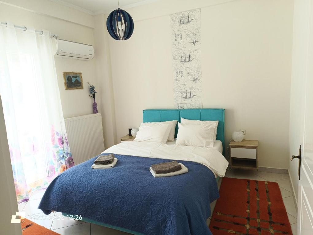 a bedroom with a blue bed with towels on it at Sweet Suites in Amalias