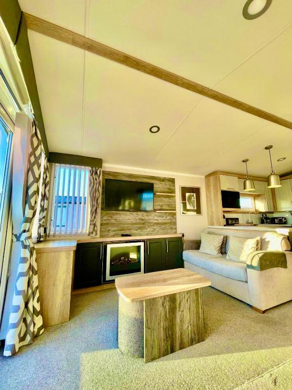 a large living room with a couch and a tv at Static in Peak District Ashbourne Heights Derbyshire Play Park Indoor Pool in Tissington