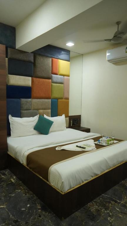 a bedroom with a large bed with a colorful wall at Near Beach HOTEL - VERSOVA INN in Jāmb