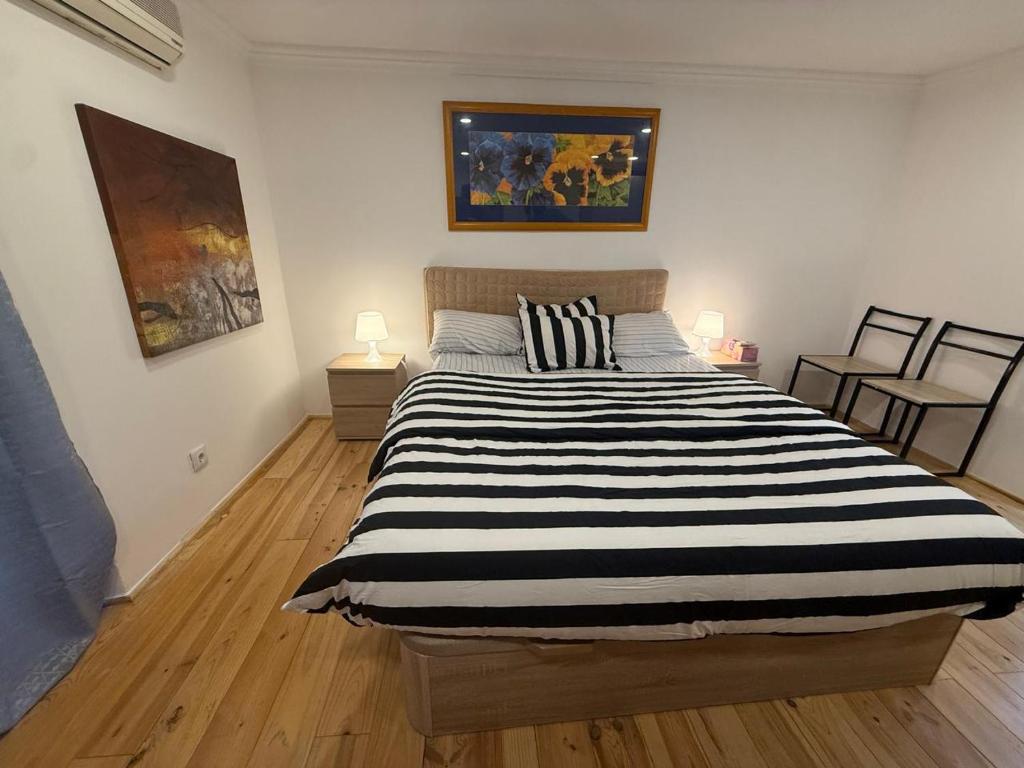 a bedroom with a large bed with black and white stripes at Rossio Downtown in Lisbon