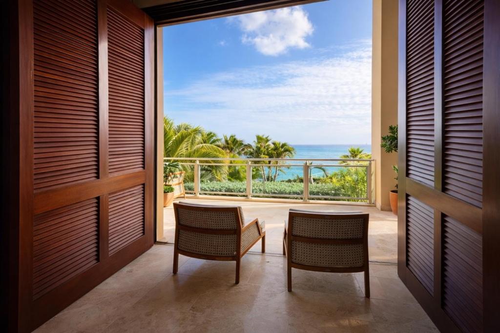 a room with a balcony with a view of the ocean at The Cliff View in Cupecoy