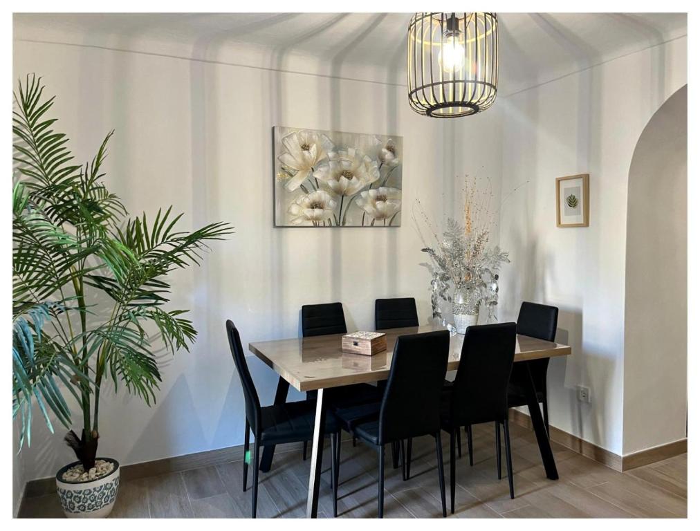 a dining room with a wooden table and black chairs at Casa Veracruz in Alora