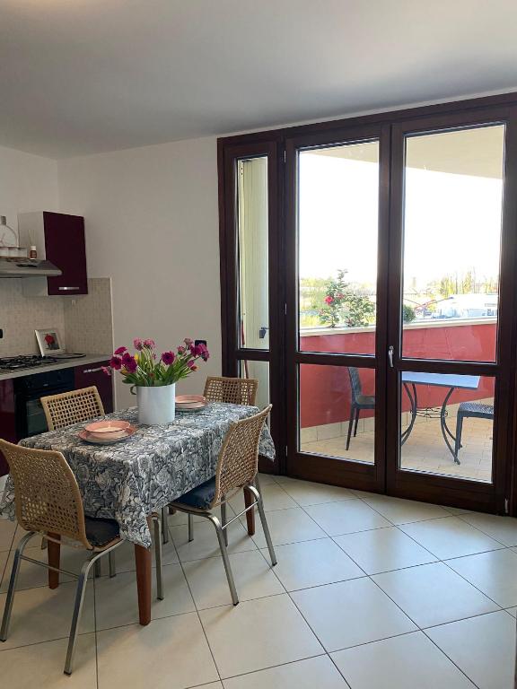 a dining room with a table and chairs and a balcony at Appartamento Gardenia in Saronno
