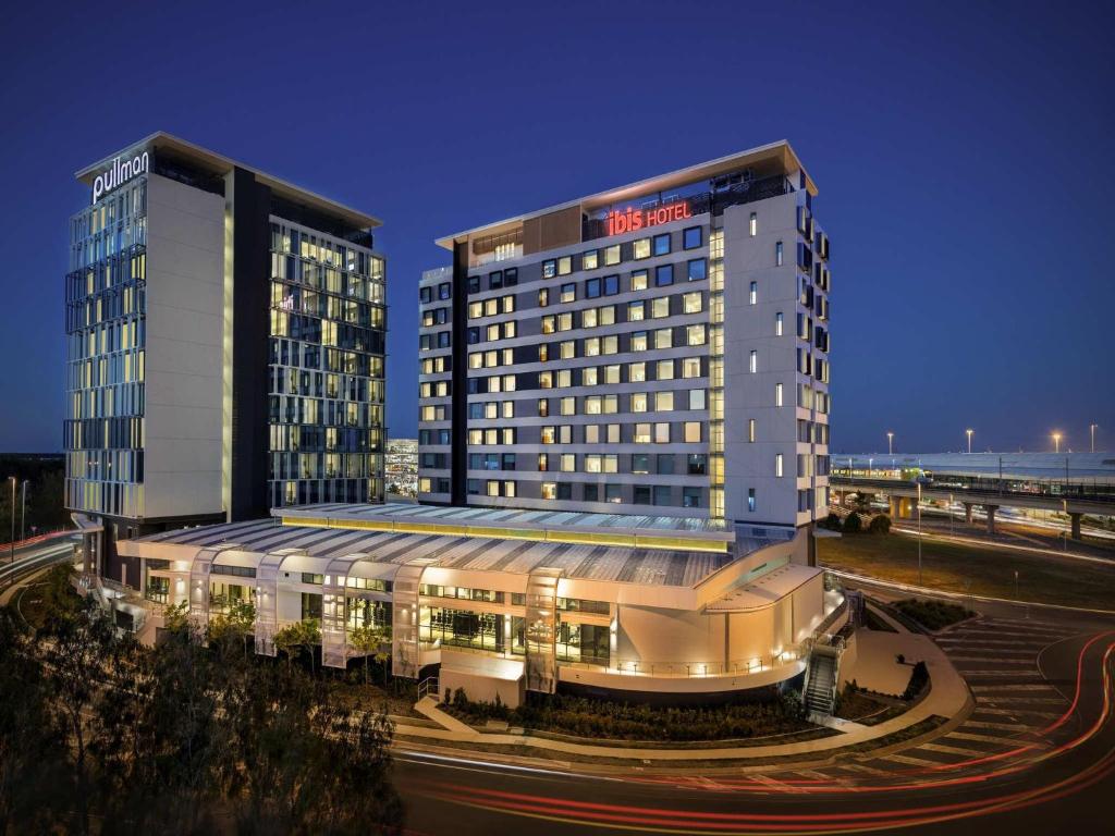 a hotel with two tall buildings at night at ibis Brisbane Airport in Brisbane