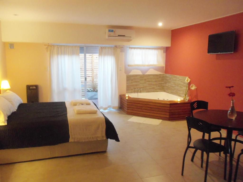 1 dormitorio con cama, bañera y mesa en Epuyen en Chascomús