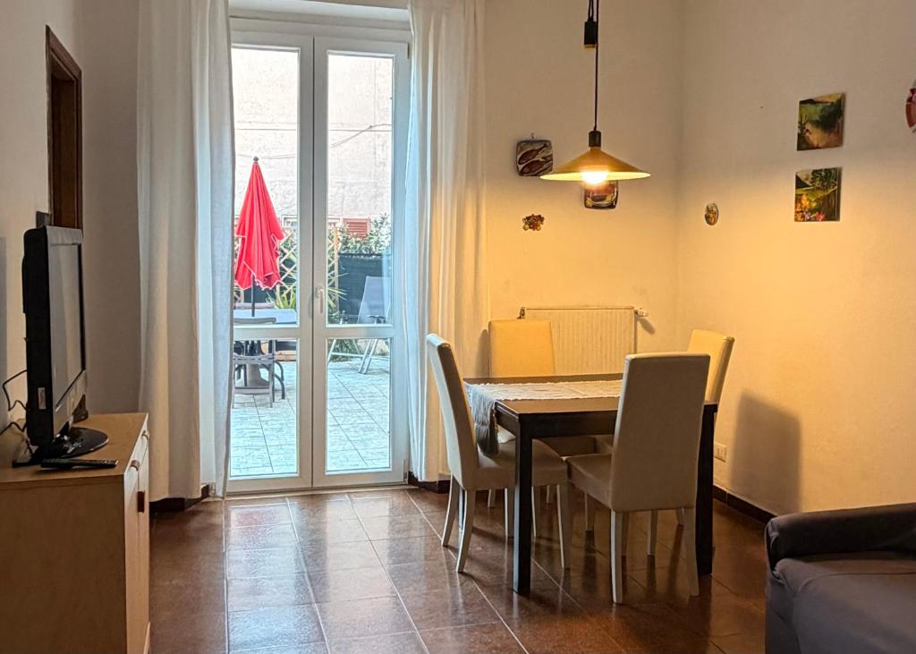a living room with a dining room table and chairs at Terrazza Le Grazie in Le Grazie