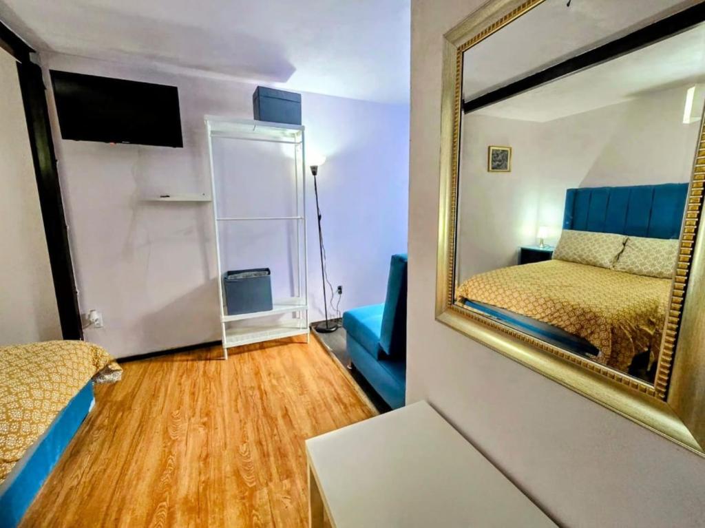 a room with a mirror and a bed and a couch at Suite Azul 3 personas comoda y equipada in Mexico City