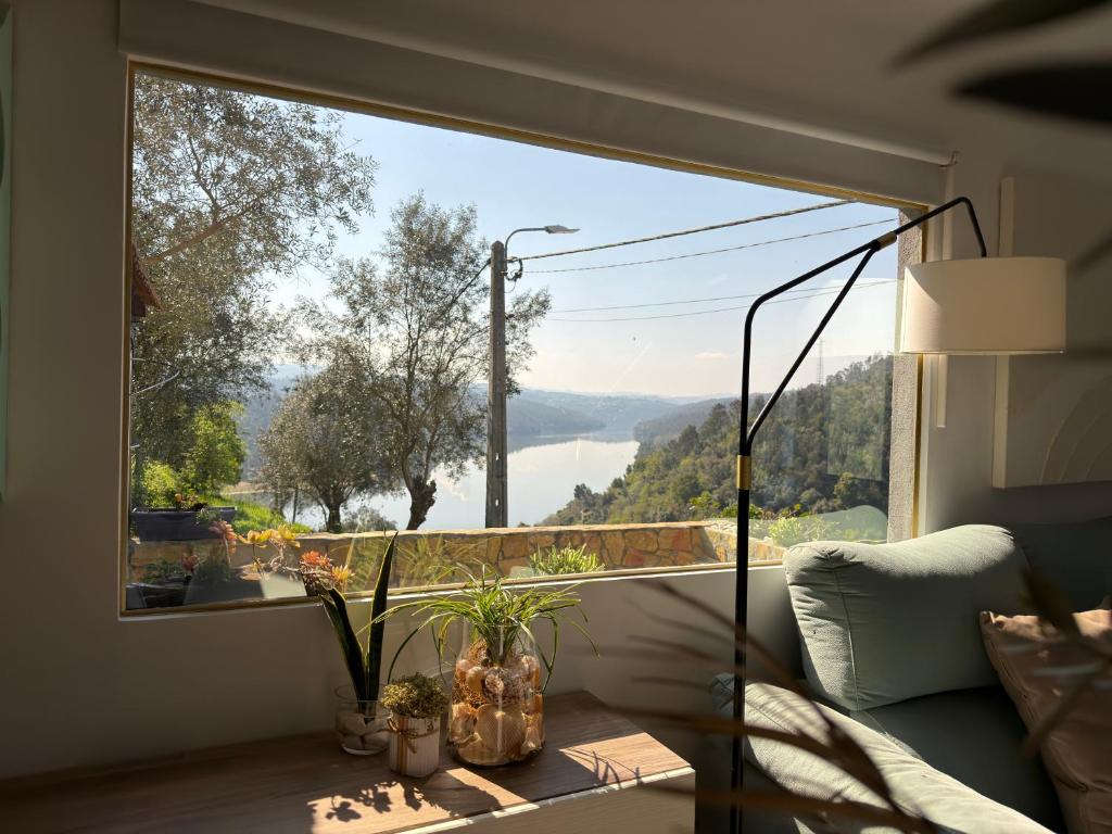 a room with a large window with a view of a lake at Douro Rural Home in Melres