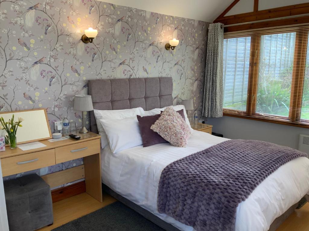 a bedroom with a bed and a desk with a computer at Whortleberry Studio B & B in Porlock