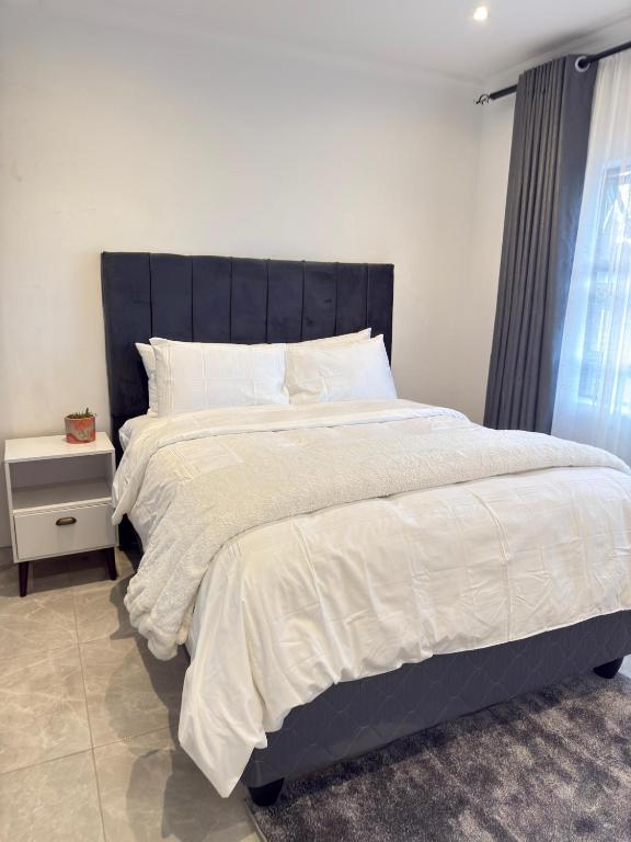 a bedroom with a large bed with a black headboard at Palmview in Bulawayo
