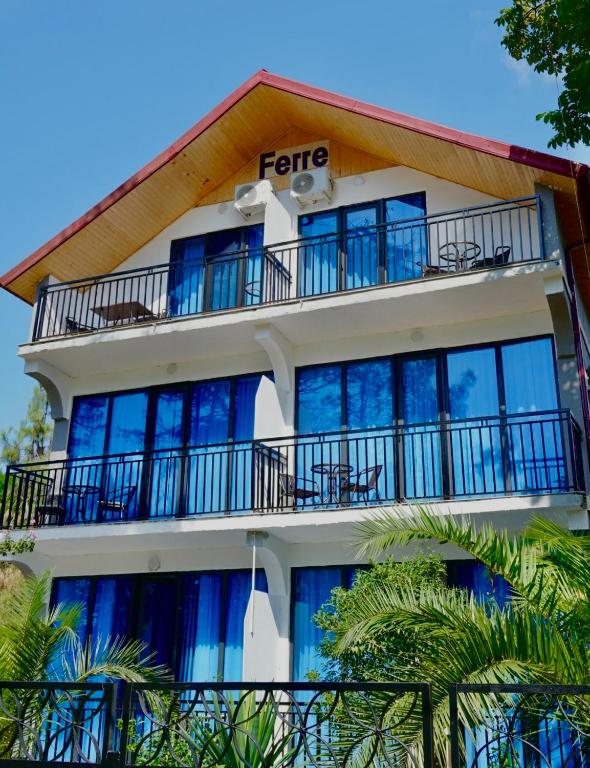a white building with blue windows and balconies at Ferre Hotel Shekvetili in Natanebis Sadguri
