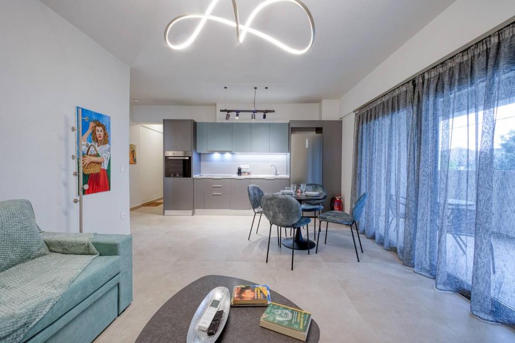 a living room with a couch and a table with chairs at Alba Luxury Suite Trikala in Tríkala