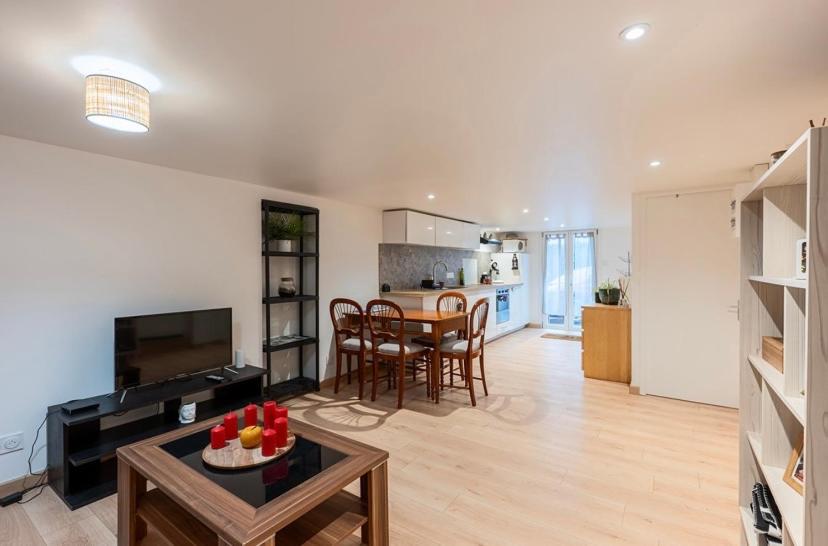 a large living room with a table and a kitchen at Le carolo in Tournes