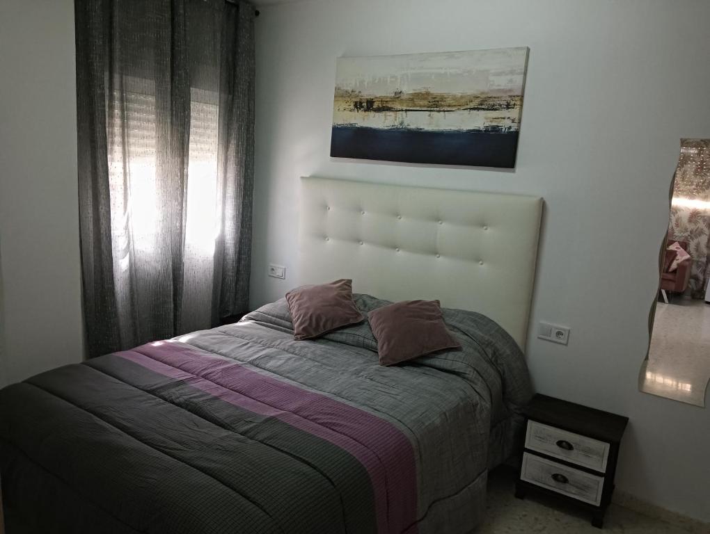 a bed with two pillows on it in a bedroom at Ágora House Alcalá de Guadaira 2 in Alcalá de Guadaira
