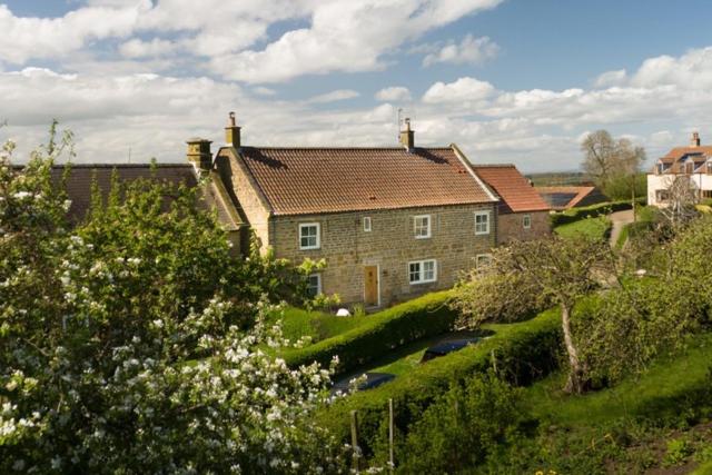 a house on a hill with cars in front of it at 4 Bed in Borrowby oc-o36892 in Borrowby