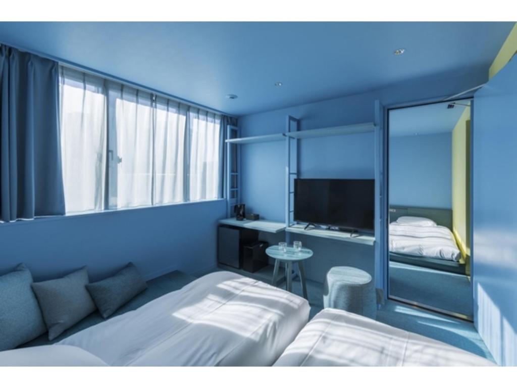 a blue room with a bed and a television at toggle hotel suidobashi - Vacation STAY 06299v in Tokyo