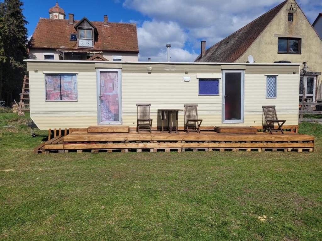 a house with a wooden deck in front of it at Mobilhome Apartments in Bechhofen