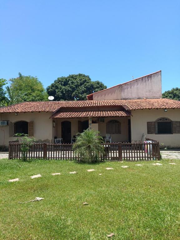 a house with a wooden fence in the yard at Casa em Saquarema praia e verde in Saquarema