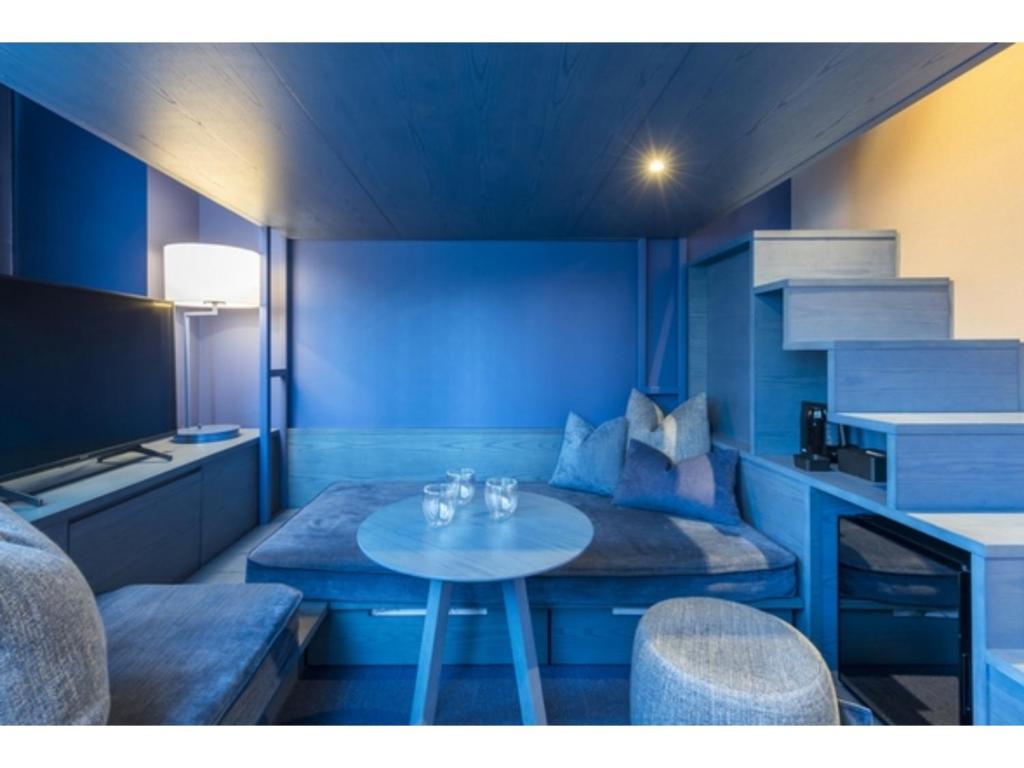 a blue room with a table and a couch at toggle hotel suidobashi - Vacation STAY 13439v in Tokyo