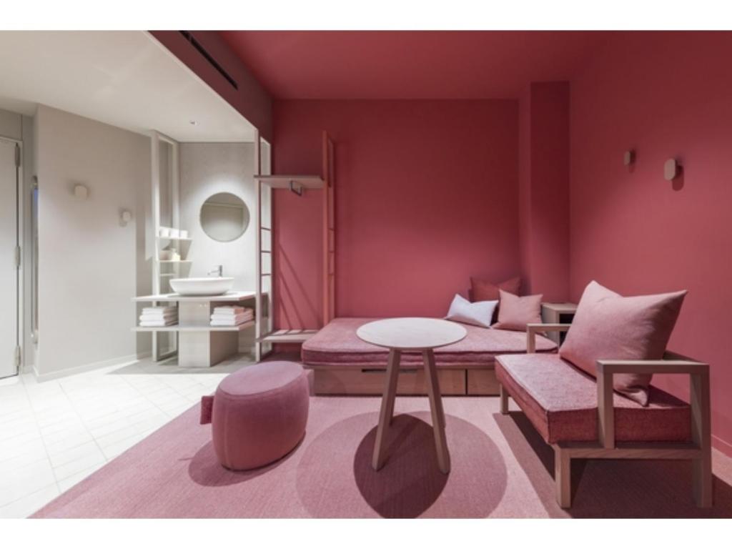 a living room with a pink room with a table and a couch at toggle hotel suidobashi - Vacation STAY 13467v in Tokyo