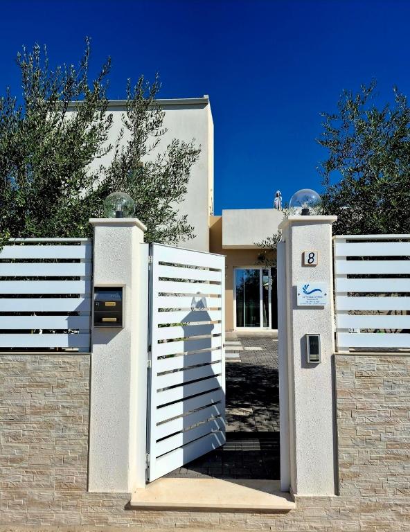 a white gate to a house with the number at La Terrazza sul Mare in Marzamemi