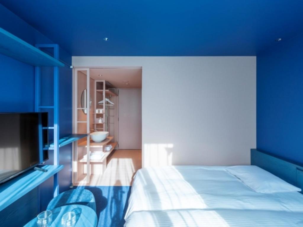 a bedroom with blue walls and a bed at toggle hotel suidobashi - Vacation STAY 18195v in Tokyo