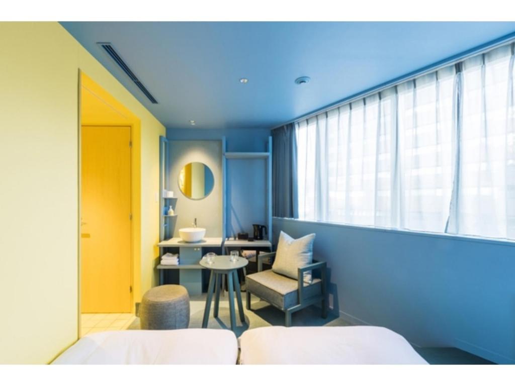 a blue room with a chair and a table at toggle hotel suidobashi - Vacation STAY 18203v in Tokyo
