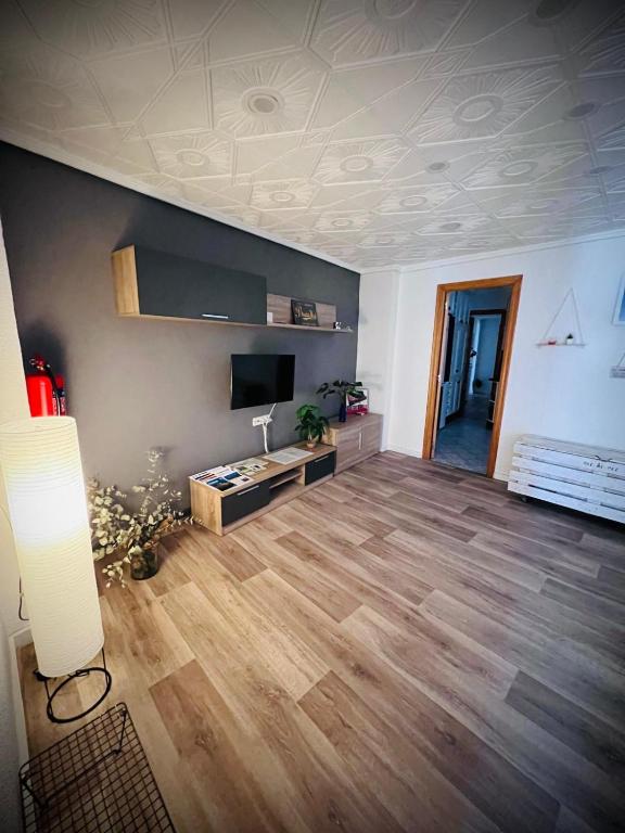 a living room with a hard wood floor and a tv at Casa Sempere in Elche