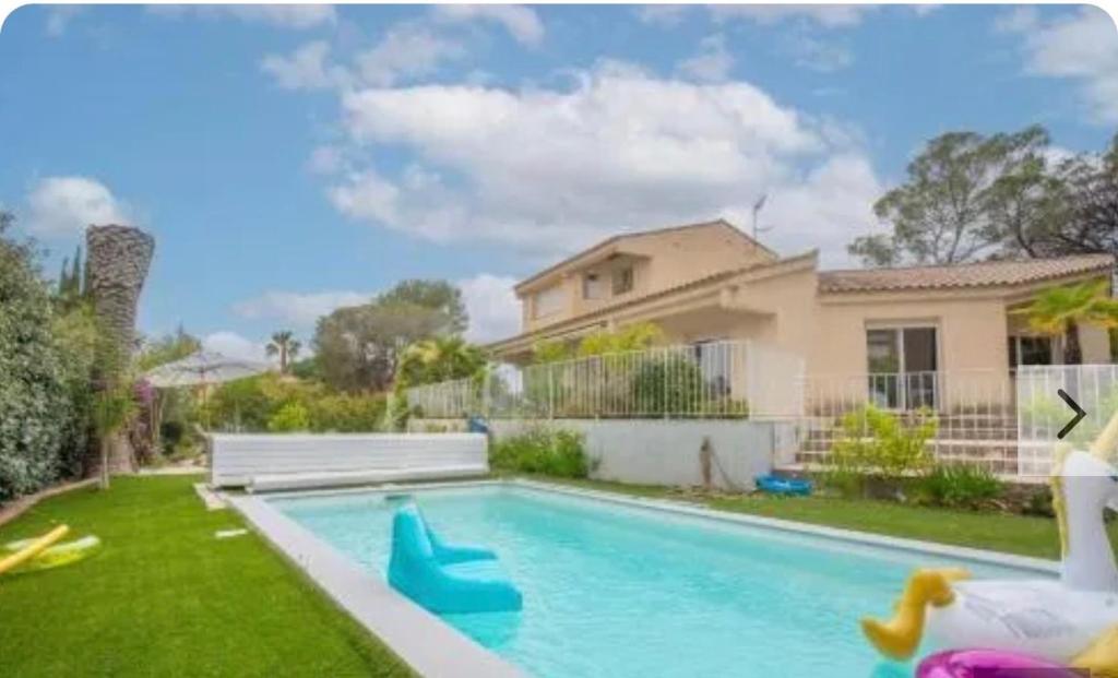 a backyard with a swimming pool and a house at Villa Osher in Saint-Raphaël