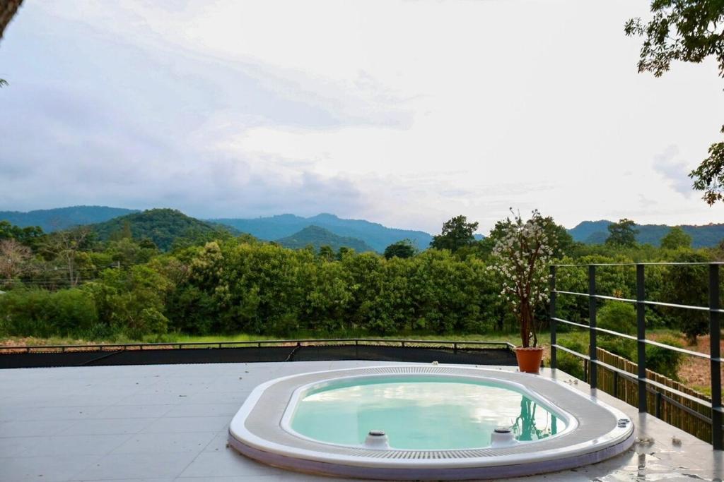 a hot tub on a patio with mountains in the background at Little Tree House in Mu Si