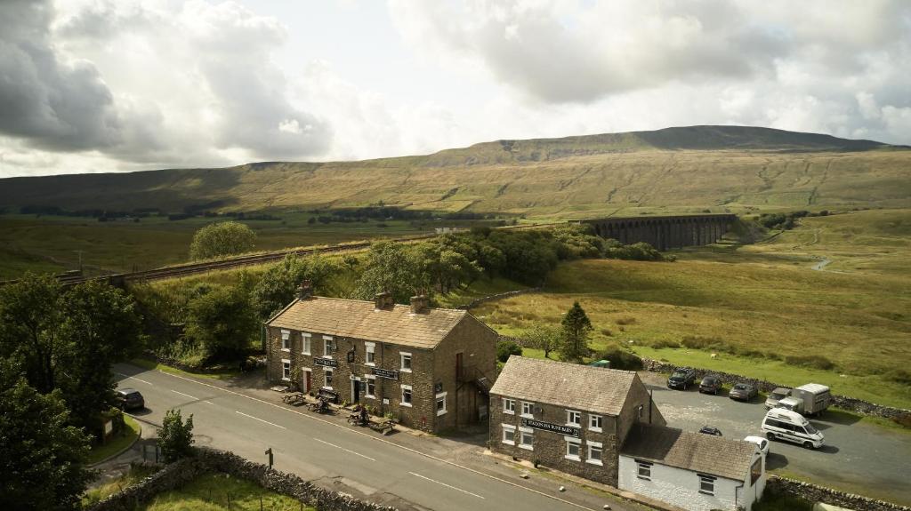 an aerial view of a house and a road in a field at The Station Inn - Ribblehead in Ribblehead Station