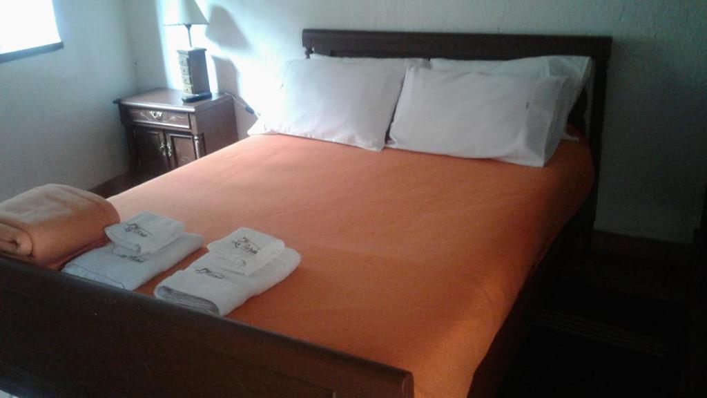 a hotel room with a bed with two towels on it at La Florida Casona Hotel in Socha