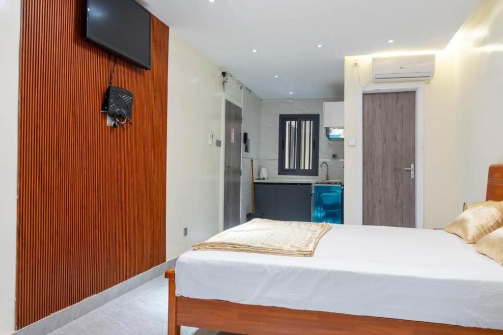 a bedroom with a bed and a tv on a wall at Résidence Madior D3 in Dakar