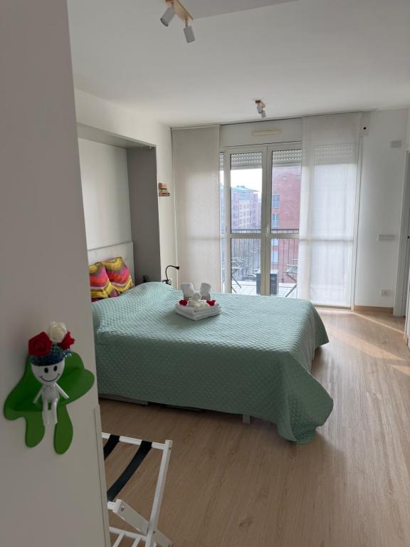 a bedroom with a bed with a green bedspread at MarteNik Apartment, vicino San Raffaele e Milano in Vimodrone